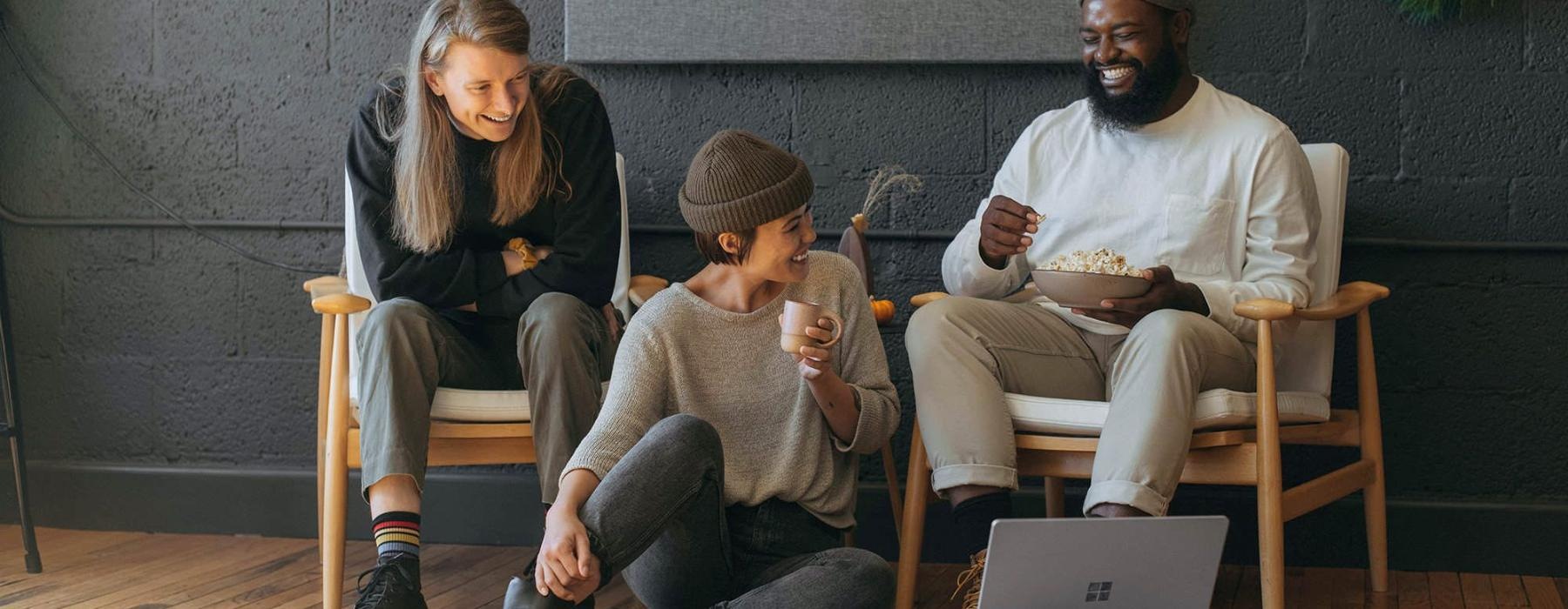 friends sit together around an open laptop