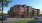 a large brick building with cars driving in front of it