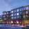 Exterior rendering of a warmly lit apartment building at dusk