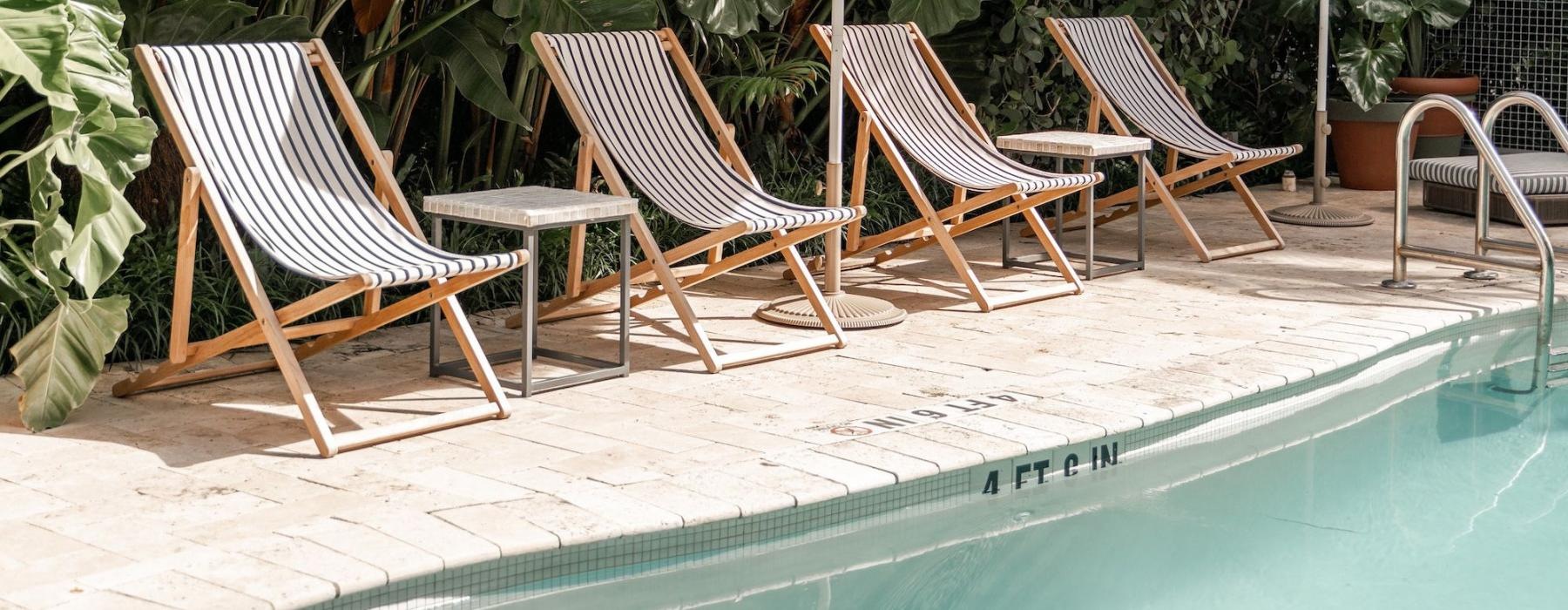 a pool with chairs and umbrellas by it